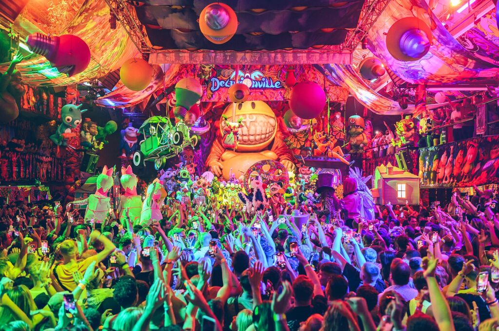 Fiesta de elrow con escenografía de colores, confeti y público bailando